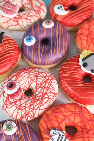 Donuts d'Halloween avec glaçage à motifs de citrouilles, araignées et décors festifs