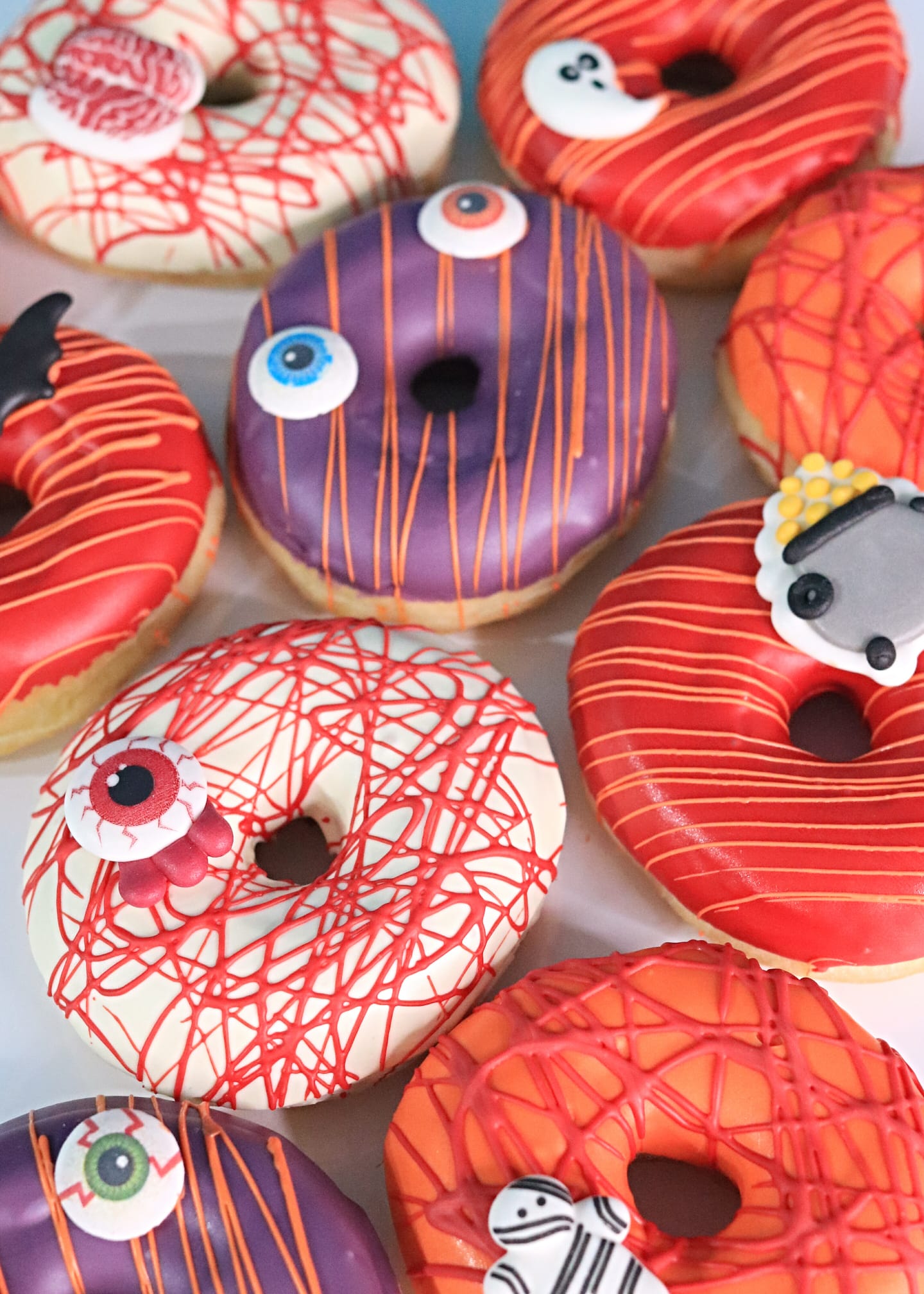 Donuts d'Halloween avec glaçage à motifs de citrouilles, araignées et décors festifs